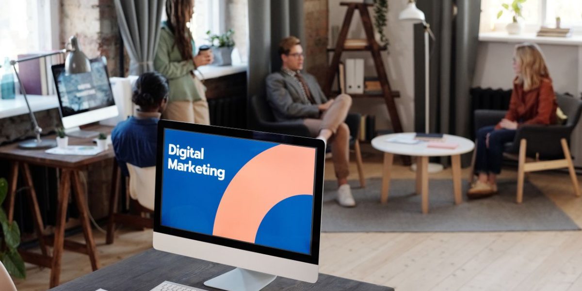 Collaborative team meeting in a modern office setting with digital marketing focus.